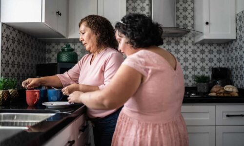 אמא מחבקת את בתה עם מוגבלות שכלית התפתחותית ומספקת תמיכה יומיומית בבית.